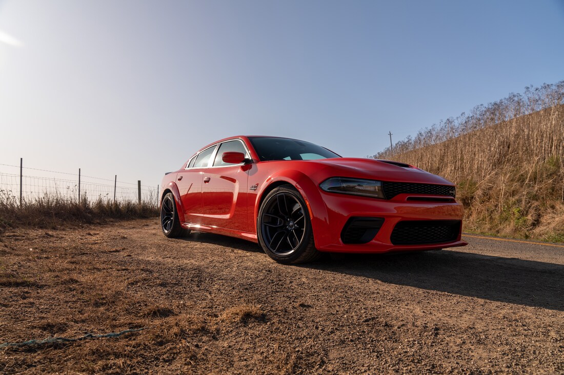 2023-Dodge-Charger-RTScatPack-Sedan-L06.png red Dodge Charger parked on a dirt road