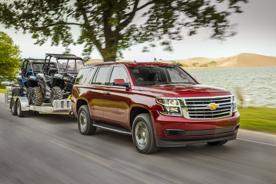 2019-Chevrolet-Tahoe-LS-SUV.png red Chevy Tahoe SUV towing two ATVs on a trailer