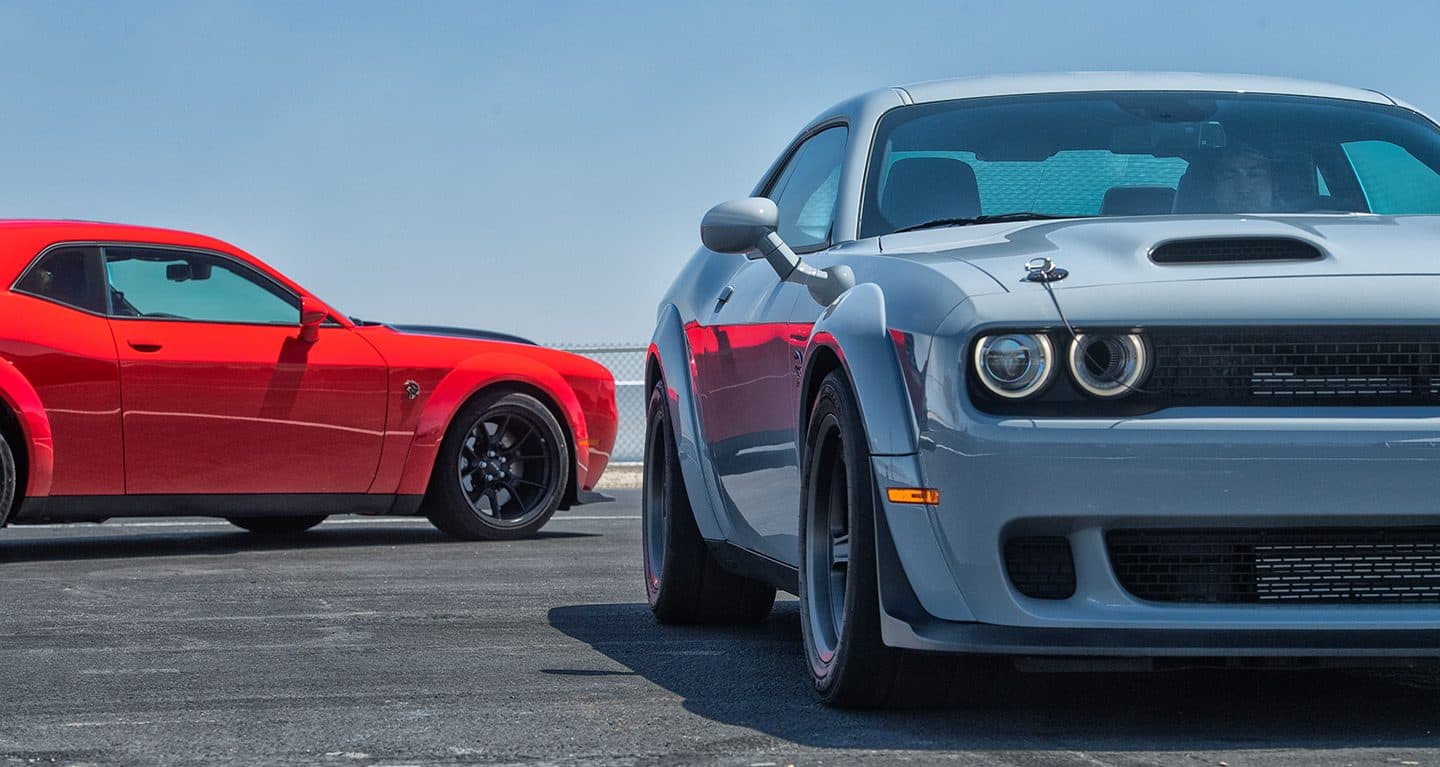 red and white Dodge Challenger parked perpendicularly to each other