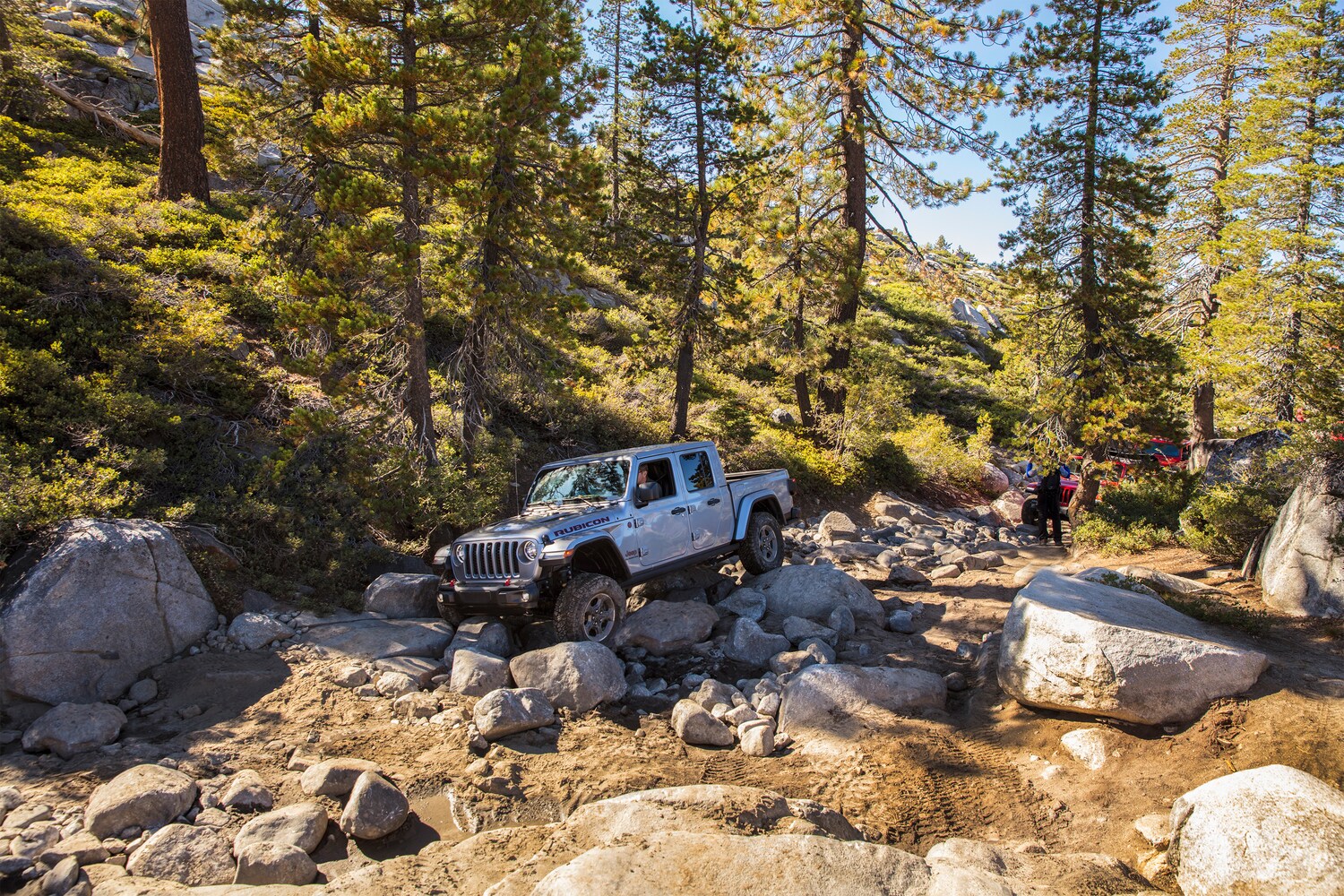 2021-Jeep-Gladiator-Rubicon-Truck-L02.png silver Jeep Gladiator Rubicon truck bouldering over rocks