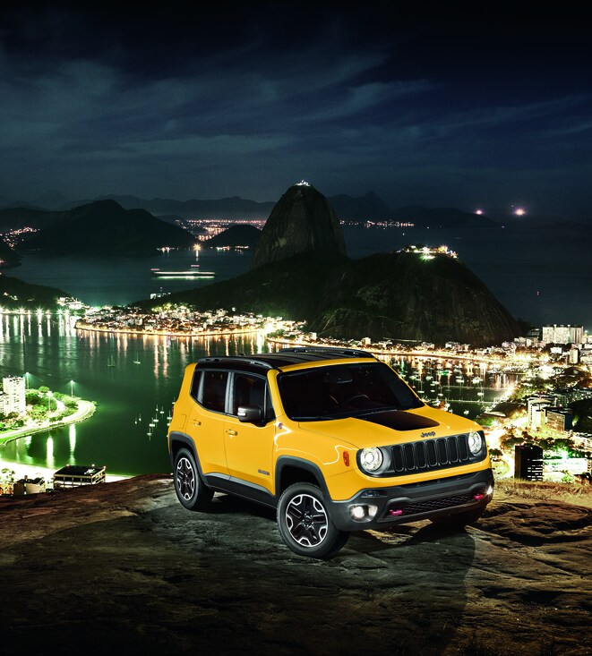 2017-Jeep-Renegade-Trailhawk-SUV-L04.png yellow Jeep Renegade SUV parked on a hill above an island city