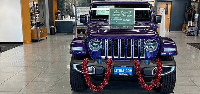 A purple Jeep Wrangler on display in the Lithia Chrysler Dodge Jeep Ram FIAT of Roseburg showroom.