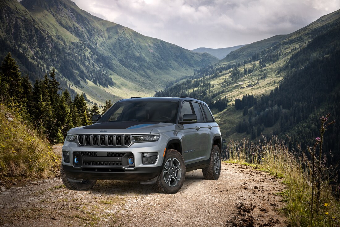 2022-Jeep-GrandCherokeeWL-4xe-Trailhawk-SUV-L09.png grey Jeep Grand Cherokee SUV parked on a dirt mountain trail