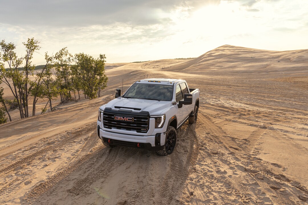 white GMC Sierra 2500 driving in desert sands