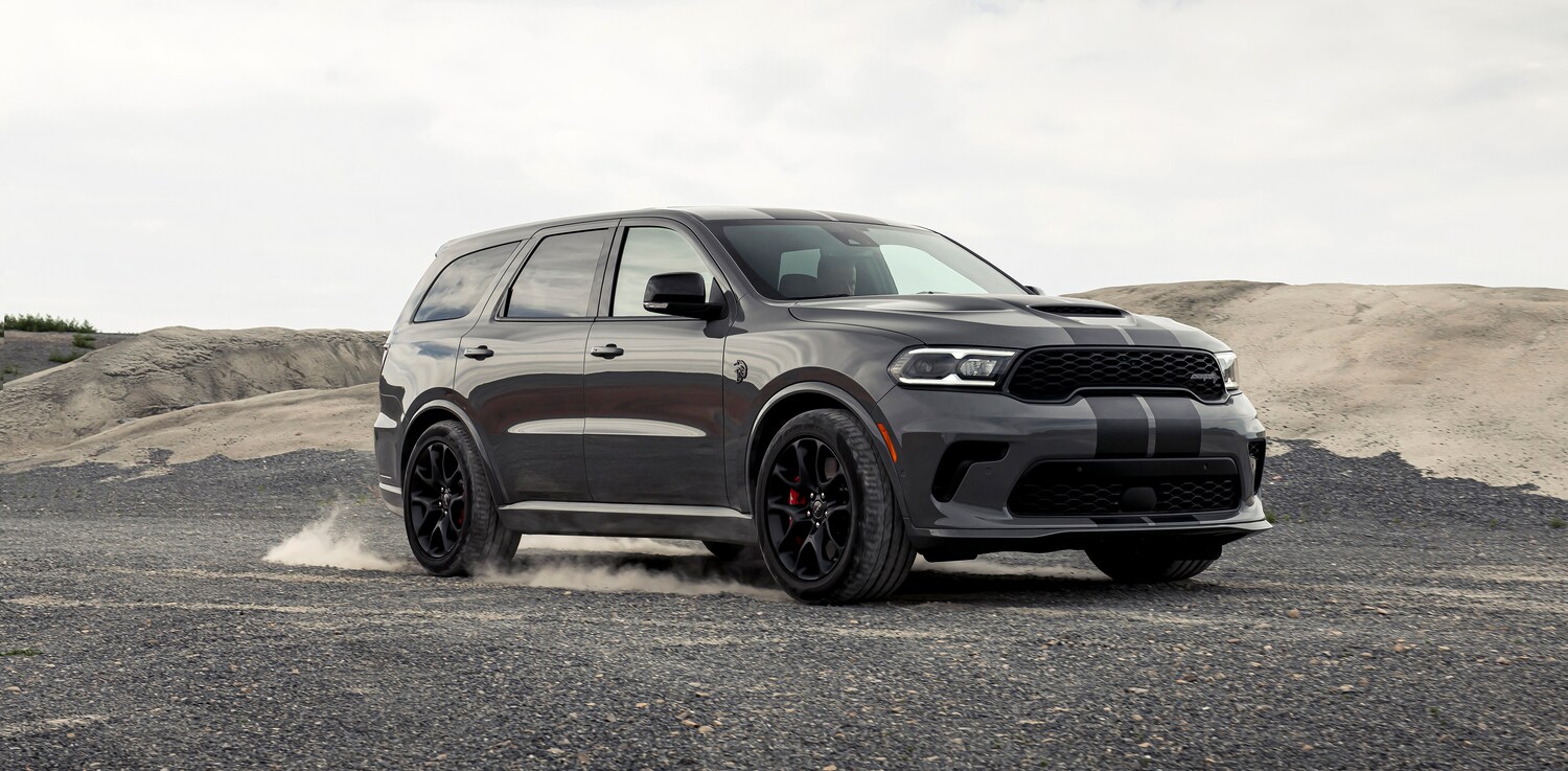 2021-Dodge-Durango-SRTHellcat-SUV.png dark gray Dodge Durango SUV parked next to a dusty gravel mound