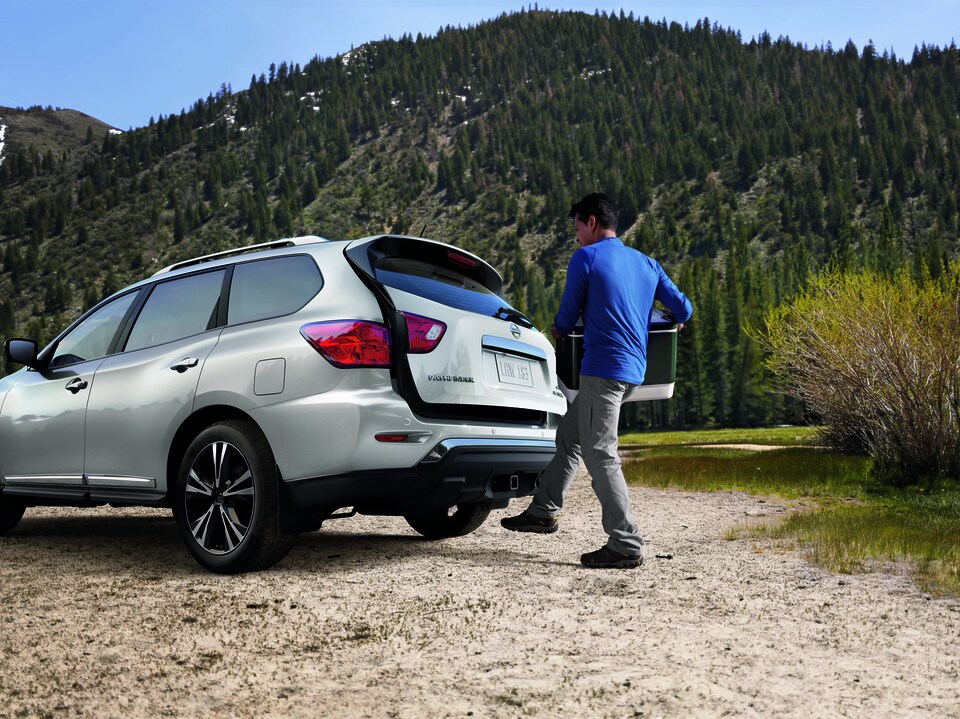 Nissan Lifestyle Camping.png white Nissan with driver using hands free liftgate