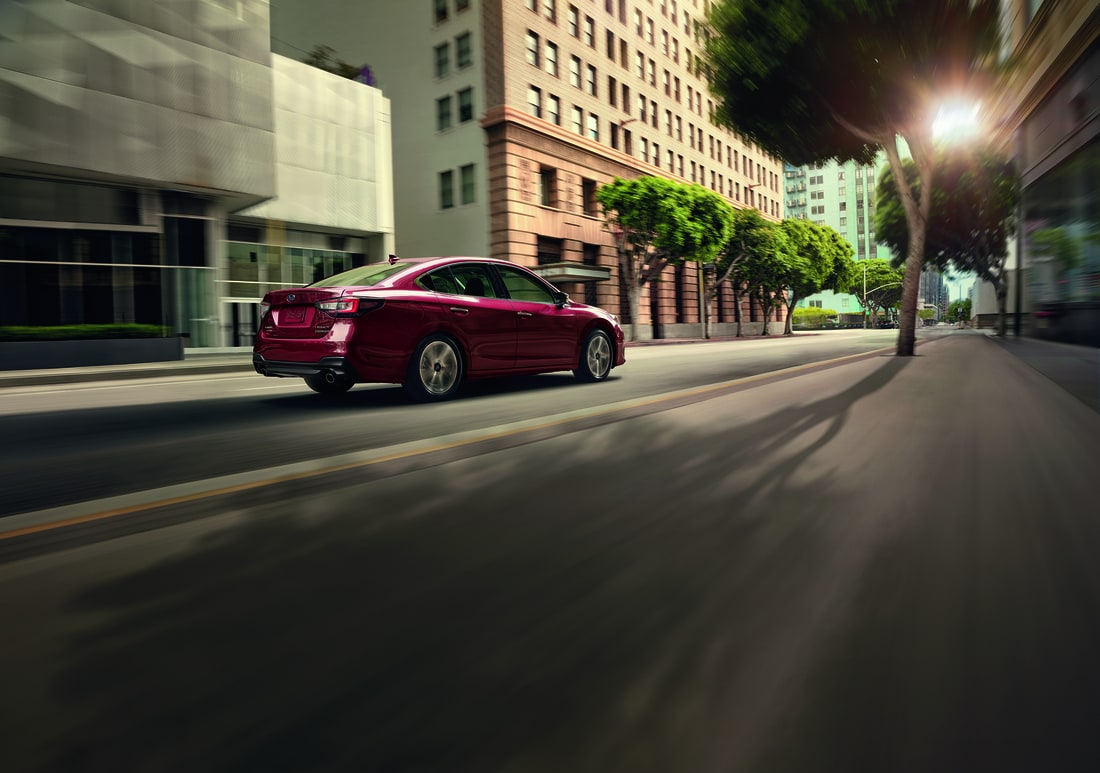 2022-Subaru-Legacy-TouringXT-Sedan-L04.png dark red Subaru Legacy sedan driving down a downtown street
