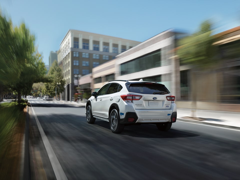 2022-Subaru-Crosstrek-Hybrid-Hatchback-L01.jpeg white Subaru Crosstrek hatchback SUV driving through the city