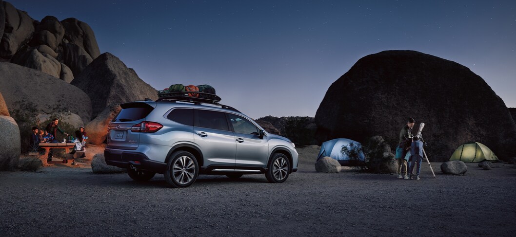 2022-Subaru-Ascent-Limited-SUV.png silver Subaru Ascent third-row SUV parked at a nighttime camp site