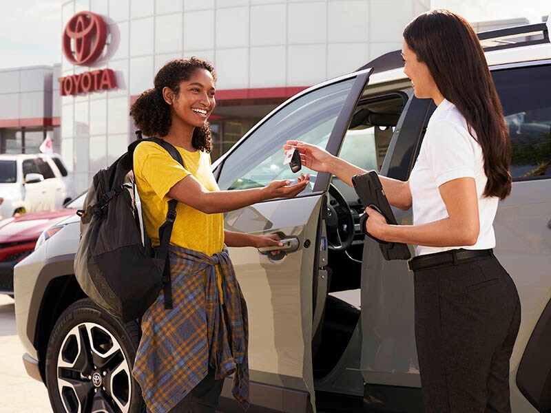 Careers at Lithia Toyota of Billings A person handing car keys to another person.