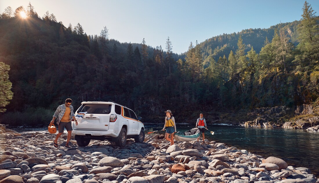2023-Toyota-4Runner-40thAnniversarySpecialEdition-SUV.png white 40th Anniversary 4Runner SUV parked on a rocky river shore with kayakers around