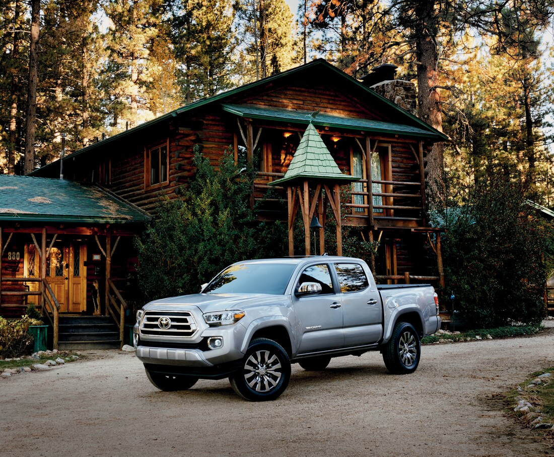 2022-Toyota-Tacoma-Limited-DoubleCab-Truck-L03.png silver Toyota Tacoma truck parked in front of a lodge in the woods