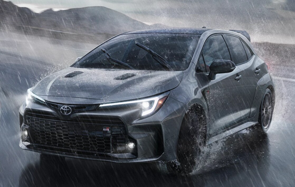 2023 GR Corolla Headlights and Grill.PNG Toyota GR Corolla coming around a track corner in the rain
