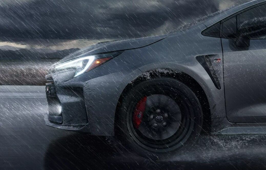 2023 GR Corolla Headlights and Tire.PNG Toyota GR Corolla profile shot of headlights and front tire in the rain