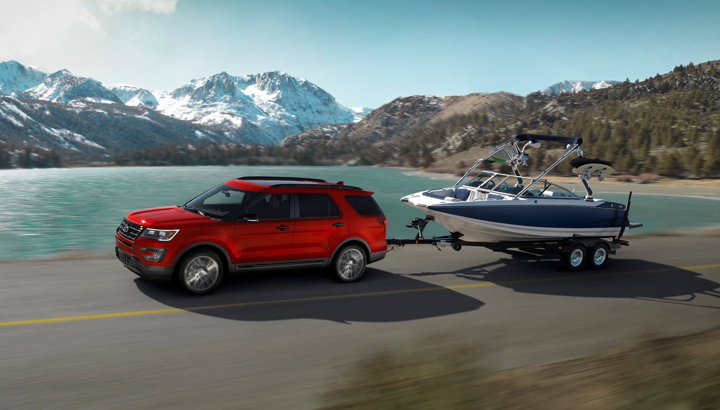 2017-Ford-Explorer-Sport-Crossover-L01 (2).png red Ford Explorer SUV towing a boat near a lake and snowy mountains