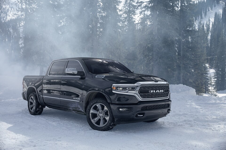 2023-RAM-1500-Limited-CrewCab-Truck-L13.png black Ram truck parked on a windy, snowy day
