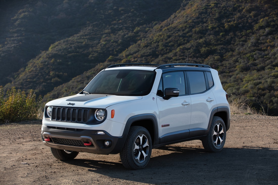 2023-Jeep-Renegade-Trailhawk-SUV-L01.png white Jeep Renegade SUV parked on a ledge in the middle of the forest