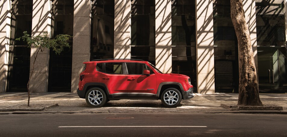 2022-Jeep-Renegade-Trailhawk-SUV-L02 (3).png red Jeep Renegade Trailhawk SUV parked in front of a modern building