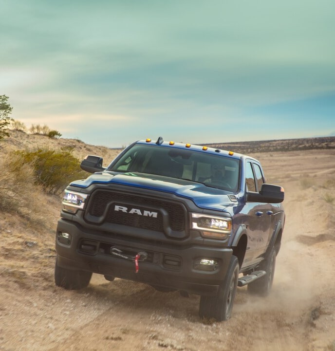 RAM 2500 blue Ram 2500 truck driving on a dirt trail