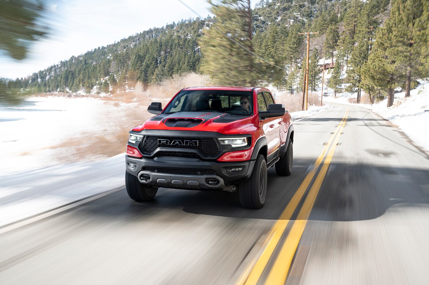 RAM-1500 red and black Ram 1500 driving fast on a snowy road