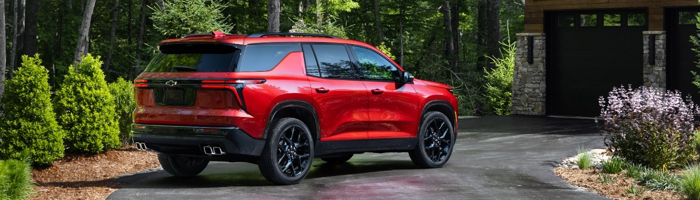 New Chevy Traverse parked near a rustic home 2025 Chevy Traverse