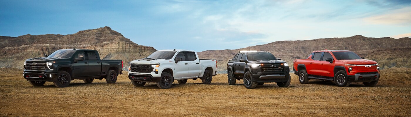 Chevy Truck Lineup Chevy Truck Lineup of trucks
parked together next to a mountain