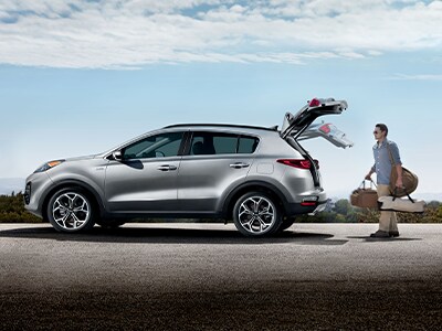 Man loading trunk of Kia Sportage