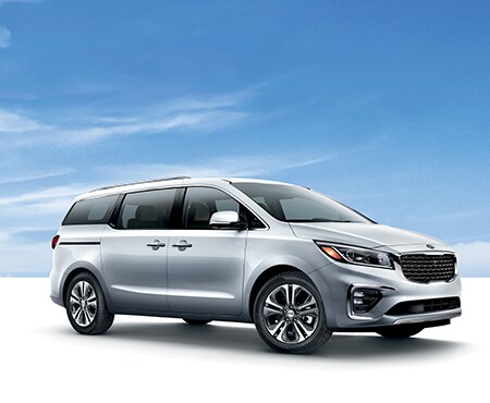 White Kia Sedona on blue background