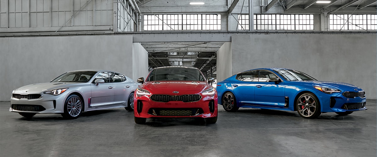 Silver, Red, and Blue Kia Stinger parked in warehouse