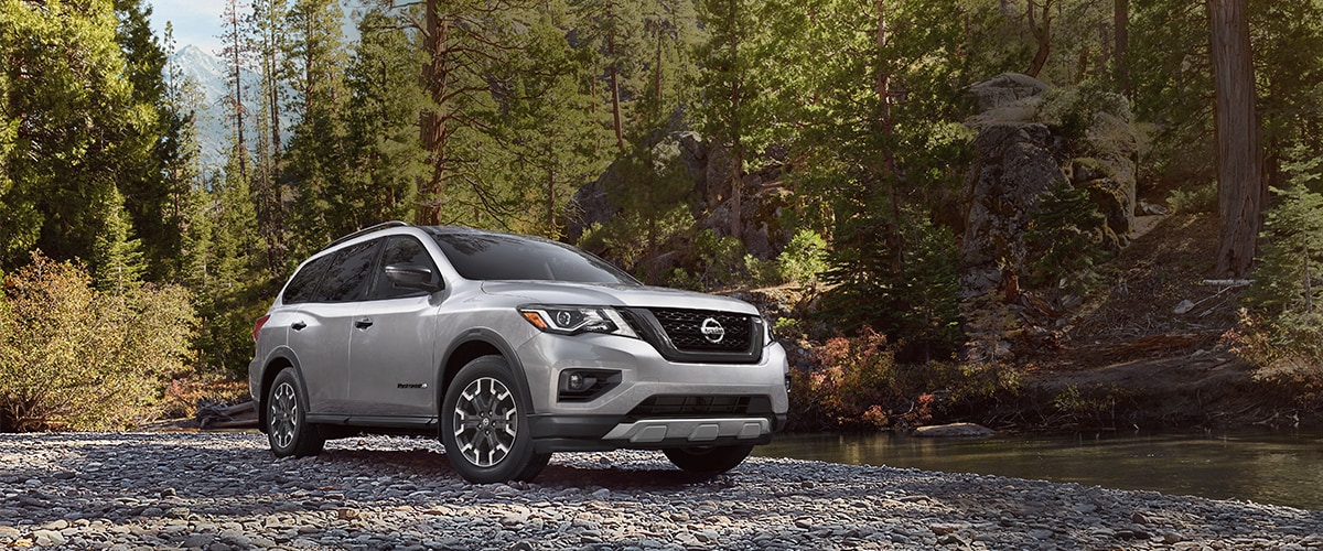Silver Nissan Pathfinder parked near stream