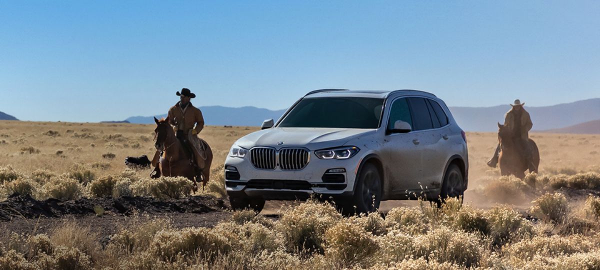 2021 BMW X5 xDrive40i xLineDesign-SUV in prarie with cowboys on horseback_long.jpeg