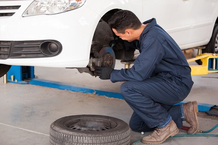mechanic fixing the brakes on a luxury car