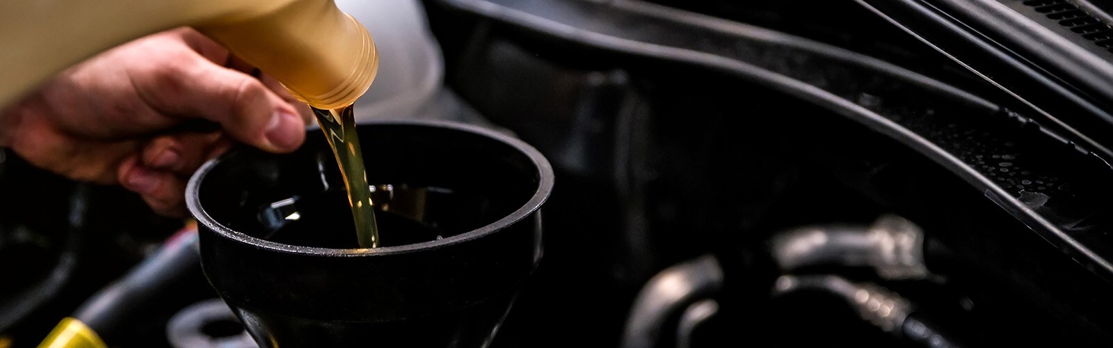 close-up-of-mechanic-adding-oil-with-a-funnel-2024-10-18-05-11-59-utc.jpg