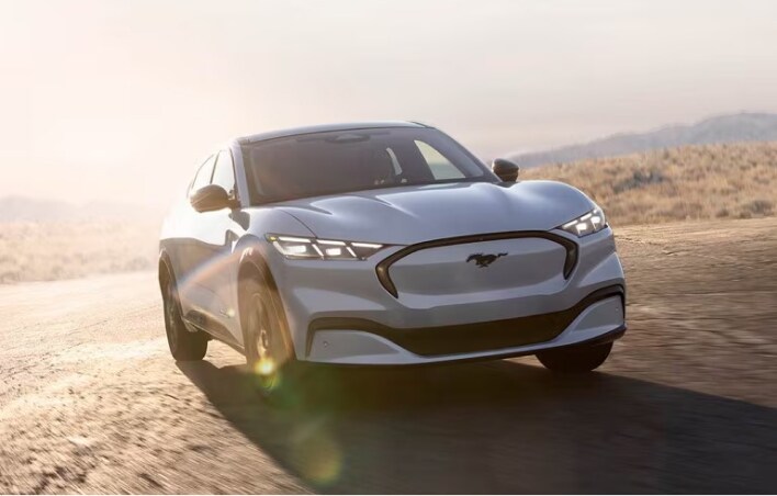 Ford Sedan driving on desert road