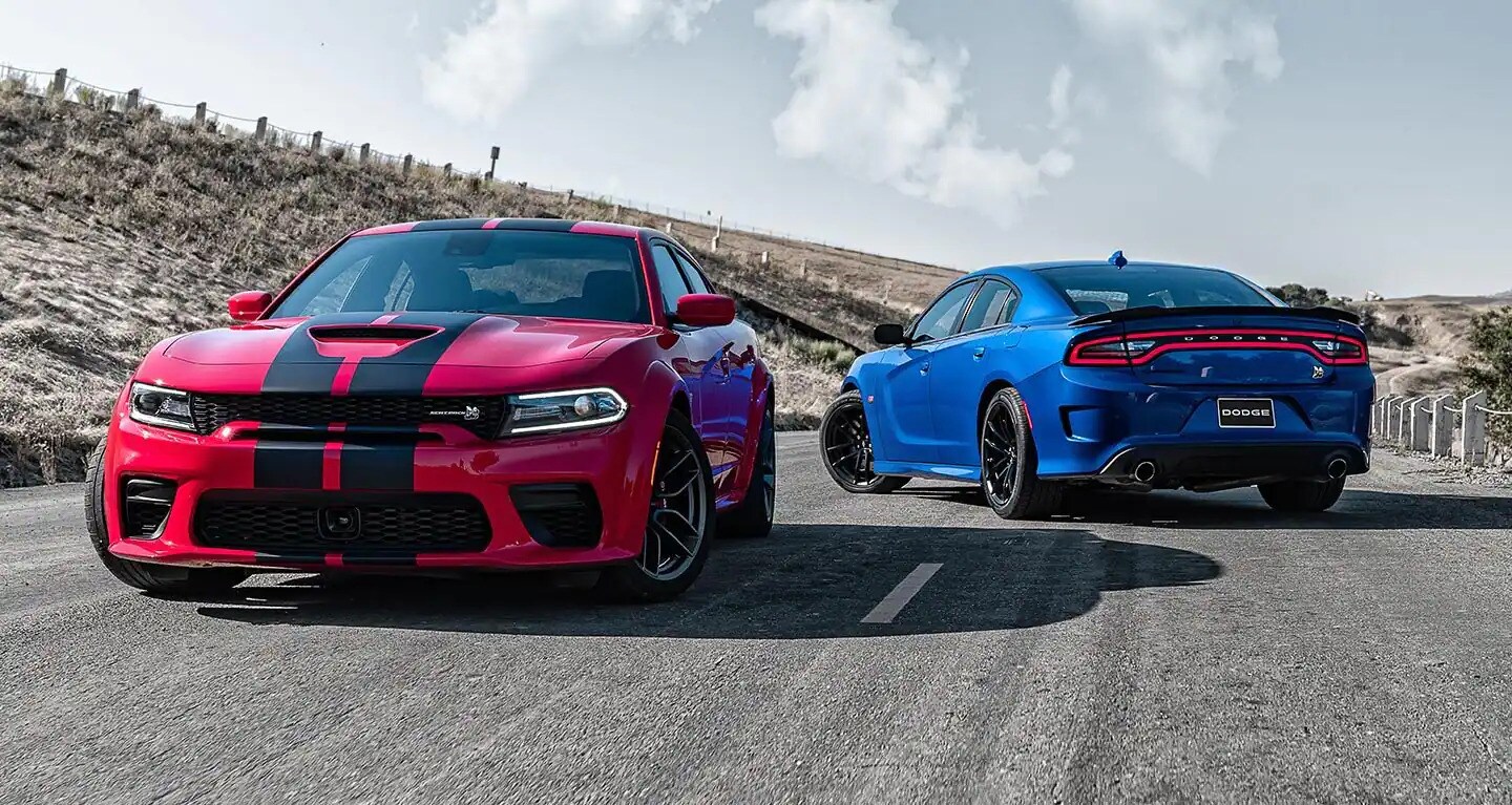Research New 2025 Dodge Models at Jubilee Chrysler Dodge Jeep Ram two Dodge Charger's parked on an old country highway