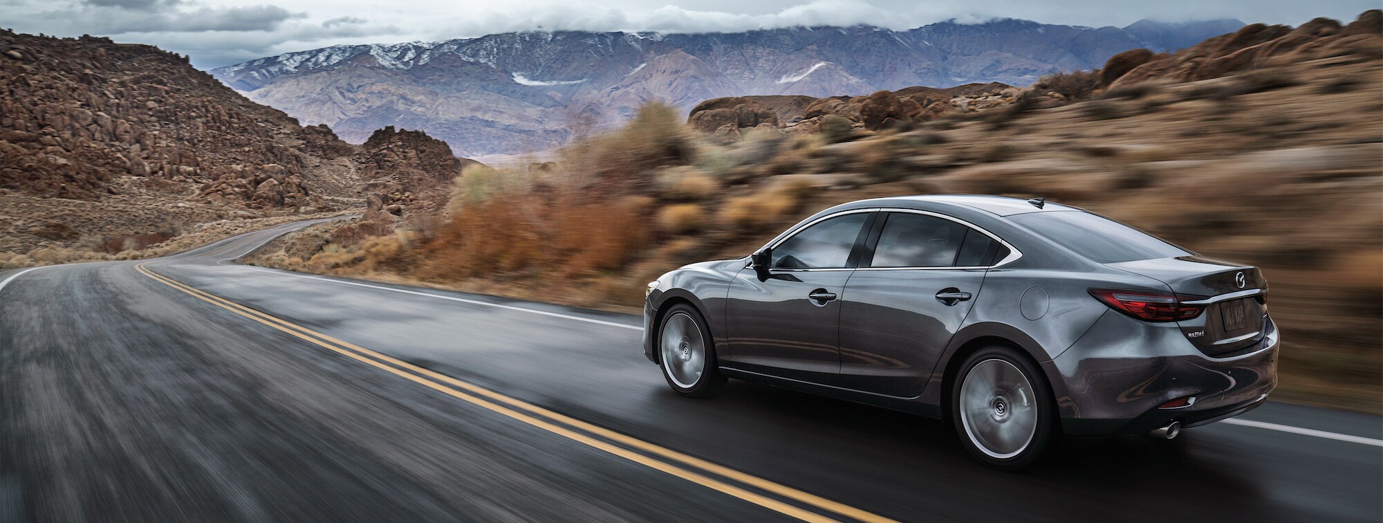 Mazda of New Bern is a car dealership near Pine Knoll Shores NC | Grey 2020 Mazda6 driving on mountain road