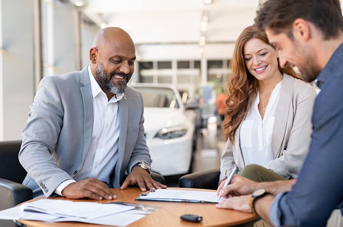 Leasing versus buying a vehicle at Mazda of New Bern in New Bern | Man signing document at a car dealership Leasing versus buying a vehicle at Mazda of New Bern in New Bern | Man signing document at a car dealership