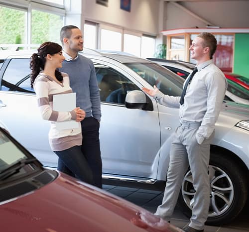 Can I trade in my leased vehicle at Mazda of New Bern | Sales agent explainging information to couple Can I trade in my leased vehicle at Mazda of New Bern | Sales agent explainging information to couple