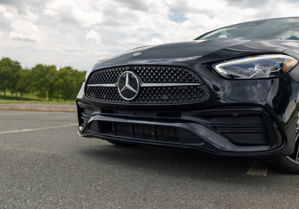 2026-mercedes-benz-c-class-specs.png Close up photo of the front grille of a new Mercedes-Benz C-Class sedan. The mercedes-benz logo is in the center of the front grille