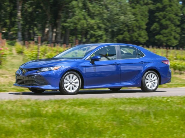 2018 Toyota Camry sedan blue in motion near grass and trees.jpg