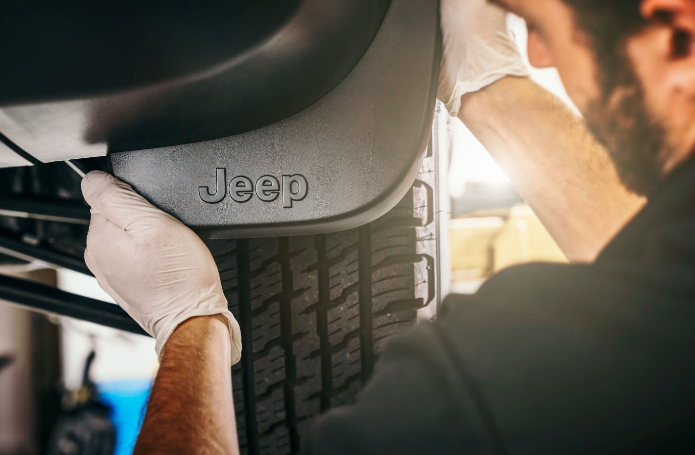 Close up of a service technician installing Mopar splash guard on a Jeep Compass Trailhawk