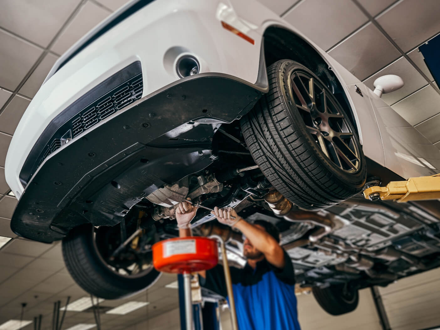 Mopar technician performing oil change service on a Dodge Challenger SRT Hellcat in White