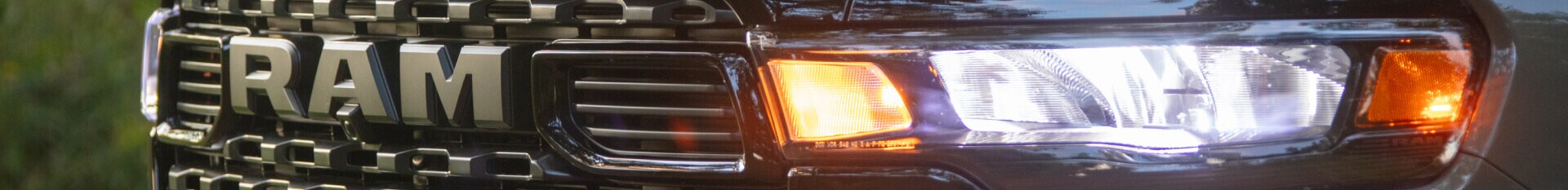 Closeup image of the grill and left headlight on a 2026 RAM 1500