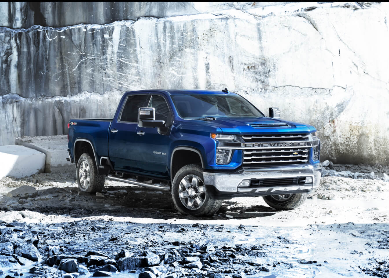 A blue Chevy Silverado parked in a snowy quarry.