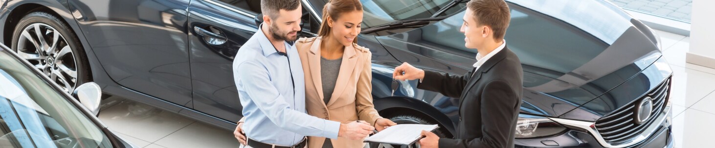 Chevrolet salesperson handing keys to new Chevy owners