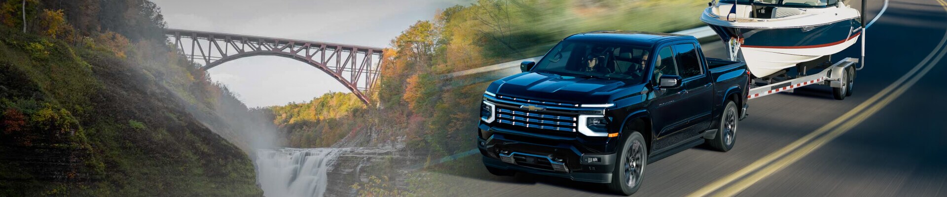 A front view of a black Chevy Silverado towing a boat along a grassy highway blended with a landscape photo of the Ausable Chasm Bridge.