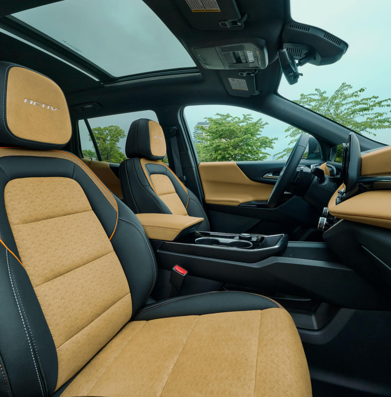 Interior side view of front seats and dashboard in tan and black Chevrolet Equinox ACTIV with sunroof.