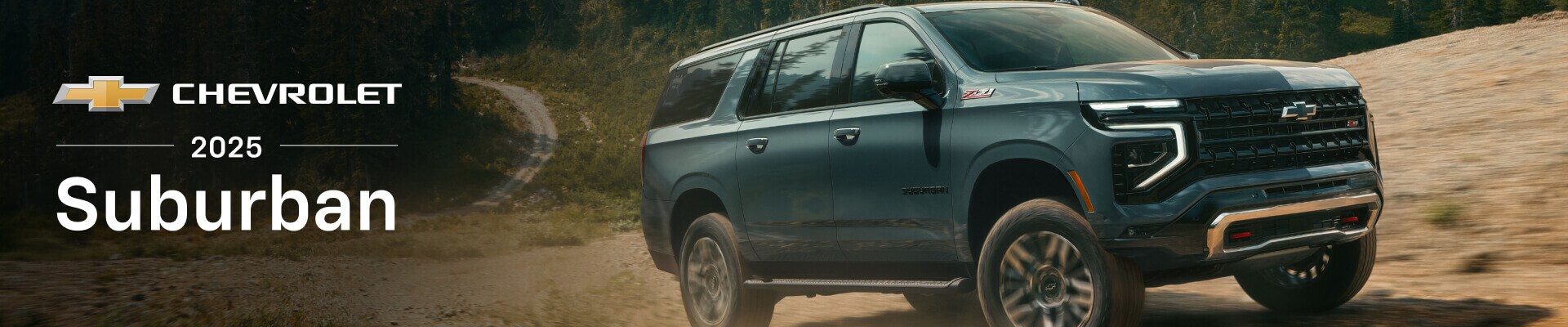 A new 2025 Chevrolet Suburban Z71 in Cypress Grey driving in mountainous off-road terrain with evergreen trees in the background