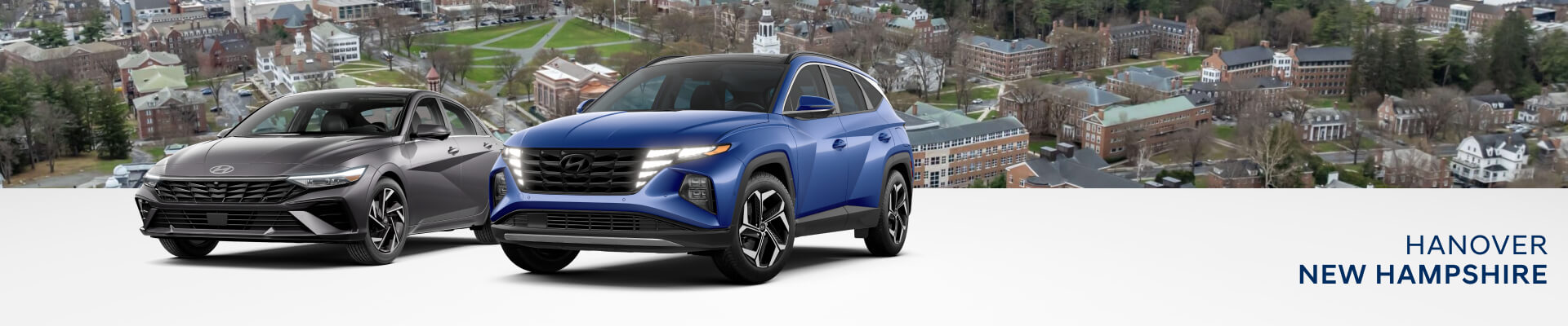 Two Hyundai SUV models displayed in front of aerial view of Hanover, New Hampshire downtown featuring historic buildings and Dartmouth College Campus