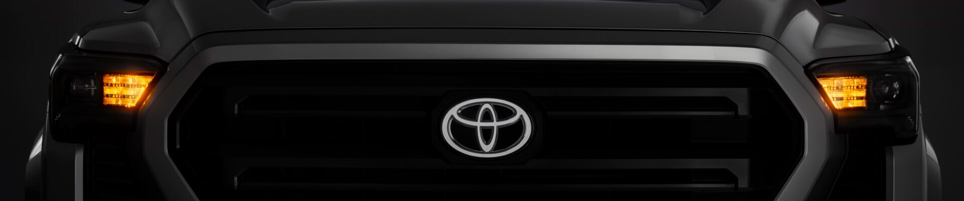 Front view of a grey Toyota Tacoma SR5 highlighting its signature horizontal bar grille design.